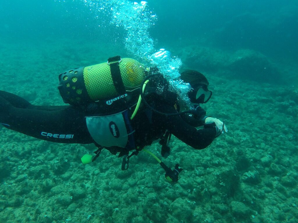Buceador y burbujas de respirador sobre fondo marino