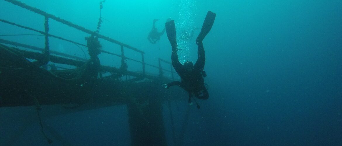 Buceadoras y estructura metálica debajo del mar